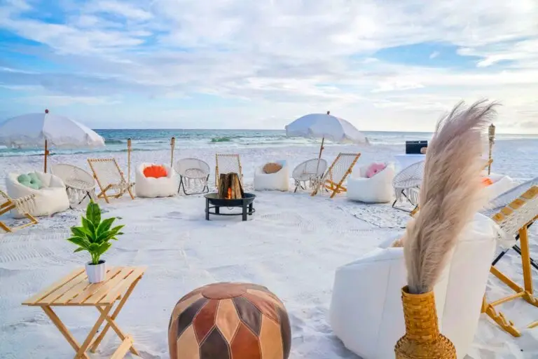Beach bonfire in Santa Rosa Beach along 30A featuring white chairs, a fire pit, and beach umbrellas.
